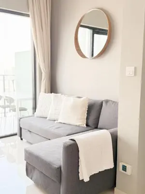 a living room with a gray couch and a mirror at CasaHue - Canal x Burj View - 4Guest - Award Winning in Dubai