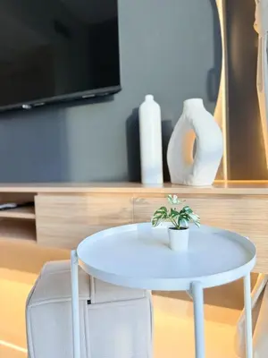 a white table with a potted plant on top of it at CasaHue - Canal x Burj View - 4Guest - Award Winning in Dubai