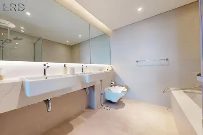 a bathroom with two sinks and a large mirror at Elegant 2BR with Maids and Stunning Canal Views in Dubai