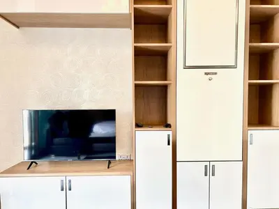 a living room with white cabinets and a tv at Homes2Retreat - Glamz Haven Stylish Studio with Balcony in Dubai