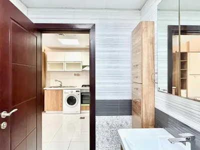 a bathroom with a sink and a washing machine at Homes2Retreat - Glamz Haven Stylish Studio with Balcony in Dubai