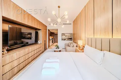 a bedroom with a large white bed and a couch at Hamilton House, Jumeirah Village Circle in Dubai