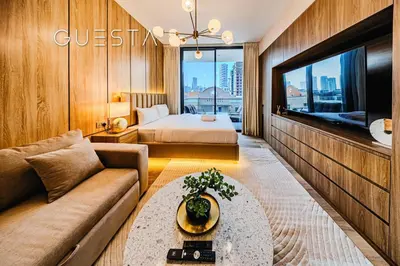 a living room with a couch and a bed and a tv at Hamilton House, Jumeirah Village Circle in Dubai