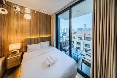 a hotel room with a bed and a large window at Hamilton House, Jumeirah Village Circle in Dubai