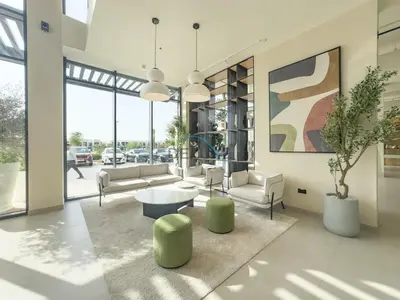 a living room with couches and a table and chairs at New Studio Close to Town Square Park, Short Drive to Al Qudra Lake, Liva Apartments by Deluxe Holiday Homes in Dubai