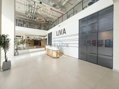 a lobby of an office building with a sign on the wall at New Studio Close to Town Square Park, Short Drive to Al Qudra Lake, Liva Apartments by Deluxe Holiday Homes in Dubai