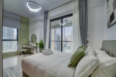 a bedroom with a large bed with a large window at Elegant Cozy Marina Home in Dubai
