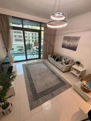 a living room with a couch and a large window at Blue Horizon Living in Dubai