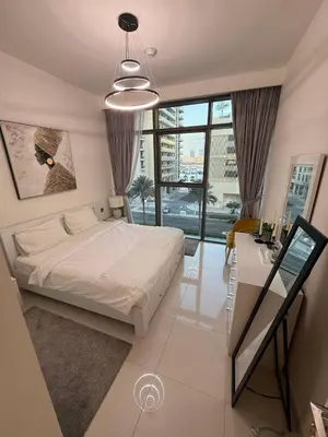 a bedroom with a white bed and a desk and window at Blue Horizon Living in Dubai