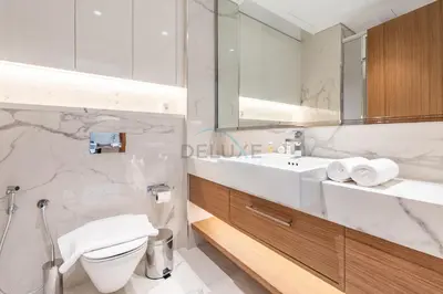 a bathroom with a sink and a toilet and a mirror at Pool and Community View Studio, Near Top Landmarks, Azizi Riviera 59, Al Merkadh by Deluxe Holiday Homes in Dubai