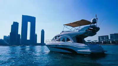 a white boat in the water in front of a city at Riviera Leisure Yachts Dubai in Dubai