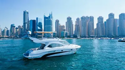 a white boat in the water in front of a city at Riviera Leisure Yachts Dubai in Dubai