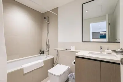 a bathroom with a tub and a toilet and a sink at High-Rise & Boulevard View - 5-min to Burj & Mall in Dubai