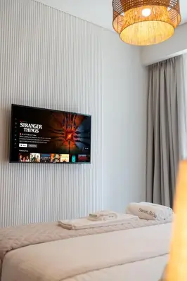 a tv hanging on a wall above a bed at Luxurious 1BR Pool with Burj Khalifa View Dubai Mall in Dubai