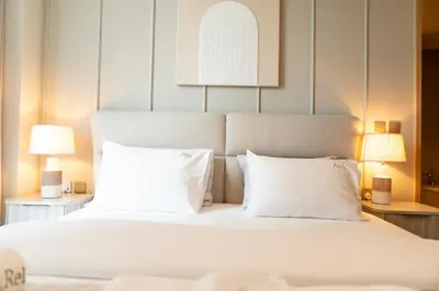 a bedroom with a white bed with two lamps at Luxurious 1BR Pool with Burj Khalifa View Dubai Mall in Dubai
