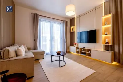 a living room with a couch and a tv at Luxury Escapes - Breathtaking 1BR with Sea View Port Lamer in Dubai