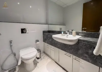 a white bathroom with a toilet and a sink at Stylish Canal Views Al Habtoor City in Dubai