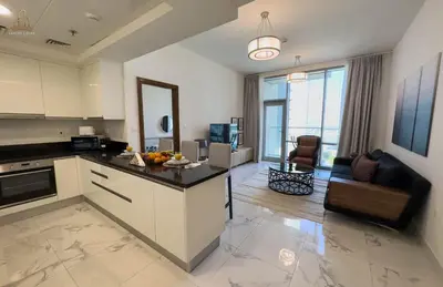 a kitchen and a living room with a counter top at Stylish Canal Views Al Habtoor City in Dubai