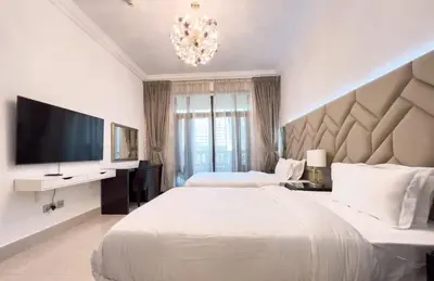 a bedroom with two beds and a flat screen tv at Upgraded 2bdr with acess to Dubai Mall in Dubai