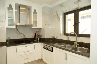 a kitchen with white cabinets and a sink and a window at Upgraded 2bdr with acess to Dubai Mall in Dubai