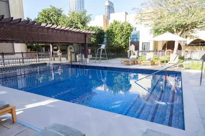 a large swimming pool with a pergola next to a building at Upgraded 2bdr with acess to Dubai Mall in Dubai