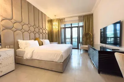 a bedroom with a large bed and a television at Upgraded 2bdr with acess to Dubai Mall in Dubai