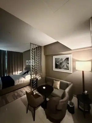 a living room with a bed and a couch and a table at Damac Prive in Dubai