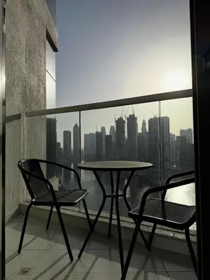 a table and two chairs on a balcony with a view at Damac Prive in Dubai