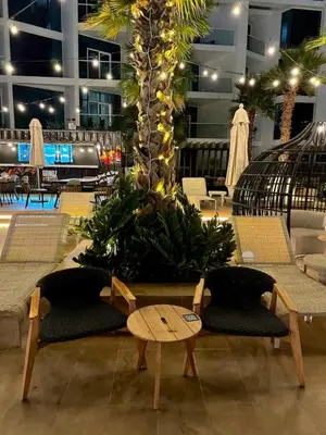 a lobby with a palm tree with chairs and a table at Damac Prive in Dubai