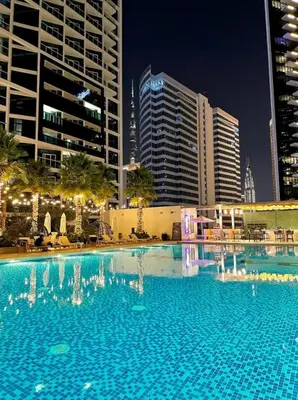 a large swimming pool in a city at night at Damac Prive in Dubai