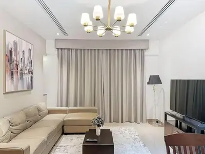 a living room with a couch and a television at Stylish 1BR in Downtown Dubai in Dubai
