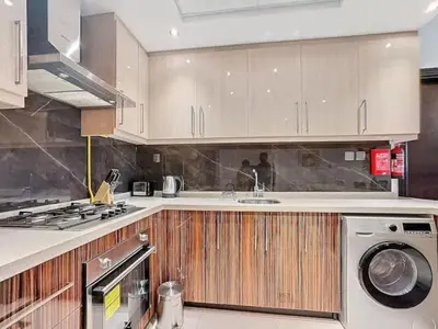 a kitchen with a sink and a washing machine at Stylish 1BR in Downtown Dubai in Dubai
