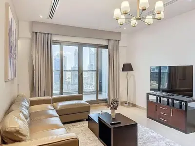 a living room with a couch and a television at Stylish 1BR in Downtown Dubai in Dubai