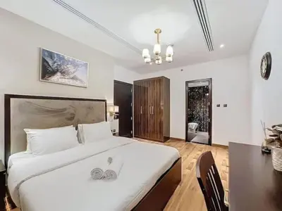 a bedroom with a large white bed with two silver rings on it at Stylish 1BR in Downtown Dubai in Dubai