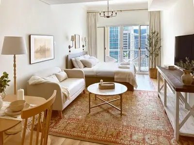 a living room with a couch and a table at Stylish Lakefront Studio with King Bed and Balcony in Dubai
