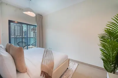 a bedroom with a bed and a large window at EasyGo-Marina Living with View and Amenities in Dubai