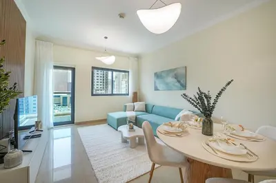 a living room with a table and a blue couch at EasyGo-Marina Living with View and Amenities in Dubai