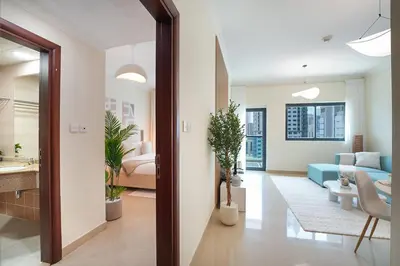 a living room with a blue couch and a bedroom at EasyGo-Marina Living with View and Amenities in Dubai