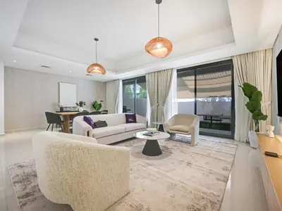 a living room with a couch and a table at 4BR Luxurious Villa DAMAC Hills 2 in Dubai