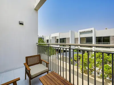 a balcony with a bench and a chair on a building at 4BR Luxurious Villa DAMAC Hills 2 in Dubai