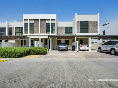 a large building with cars parked in a parking lot at 4BR Luxurious Villa DAMAC Hills 2 in Dubai