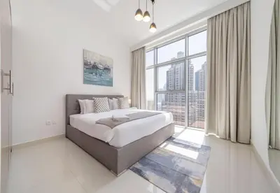 a bedroom with a large bed and a large window at Luxury 3BR Downtown Stay Near Burj in Dubai