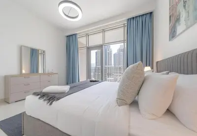 a bedroom with a large bed and a large window at Luxury 3BR Downtown Stay Near Burj in Dubai