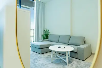 a living room with a couch and a table at FAM Living Minimalist 1BR Gem in Binghatti Amber in Dubai
