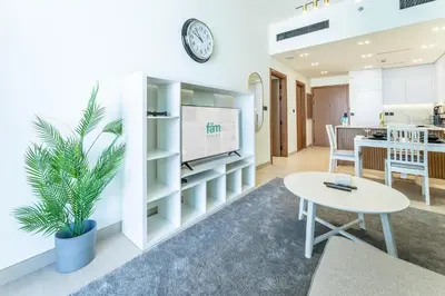 a living room with a tv and a table at FAM Living Minimalist 1BR Gem in Binghatti Amber in Dubai