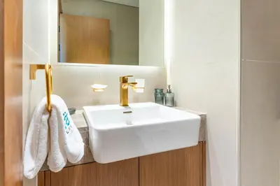 a bathroom with a white sink and a mirror at FAM Living Minimalist 1BR Gem in Binghatti Amber in Dubai