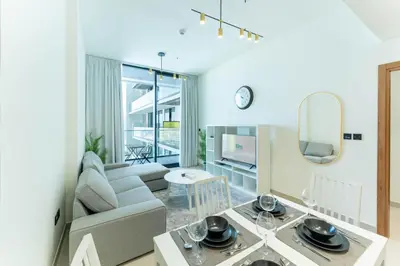a living room with a couch and a table at FAM Living Minimalist 1BR Gem in Binghatti Amber in Dubai