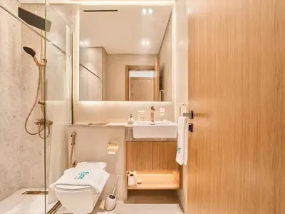 a bathroom with a toilet and a sink and a mirror at FAM Living Minimalist 1BR Gem in Binghatti Amber in Dubai