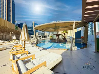 a swimming pool with chairs and a large umbrella at The Classy in Dubai