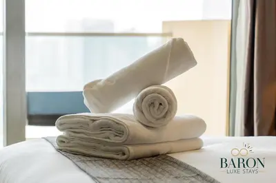 a pile of towels sitting on top of a bed at The Classy in Dubai